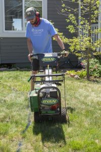 man using sod cutter to remove grass lawn