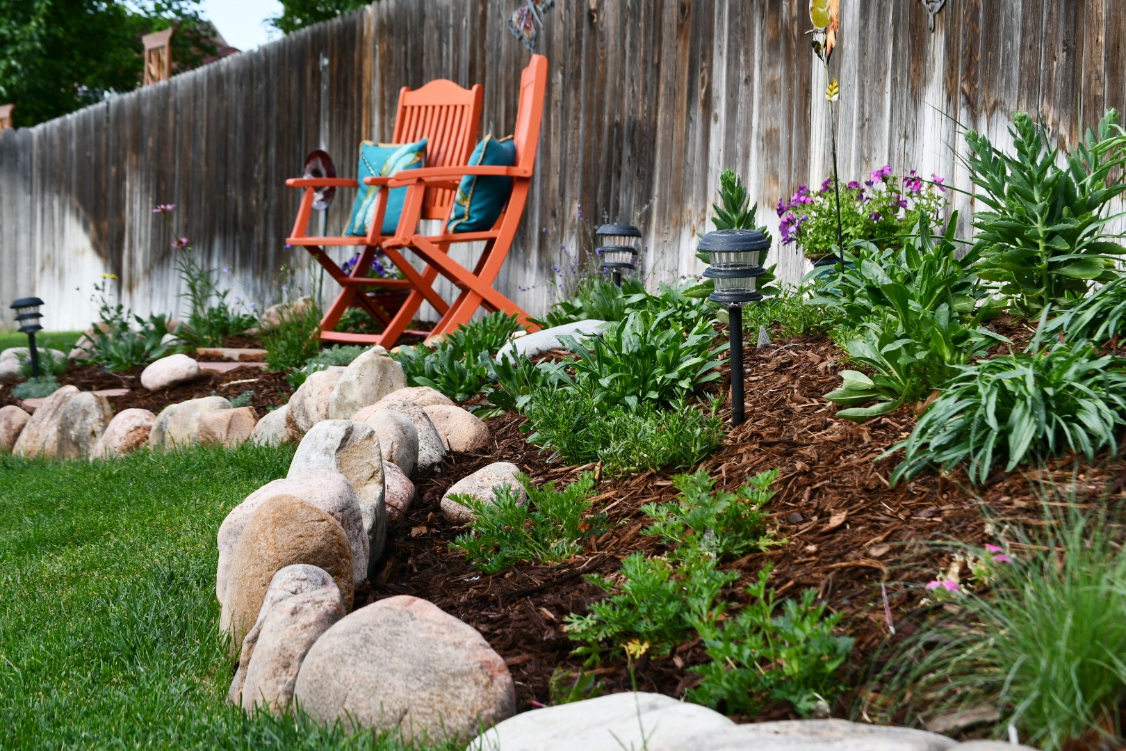 Close up of new garden, mulch, rocks, and sitting area