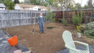 gardener working to spread mulch in new garden